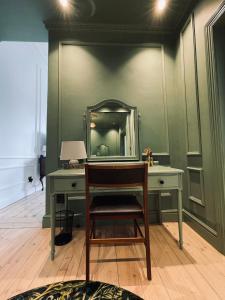 a desk with a mirror and a chair in a room at Suite Martinique at Slivington Manor in Cape Town