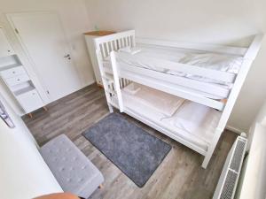 Zimmer mit 2 Etagenbetten und einem Teppich in der Unterkunft Knutt 1 in Greetsiel