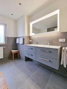 ein Badezimmer mit einem Waschbecken und einem großen Spiegel in der Unterkunft Knutt 1 in Greetsiel