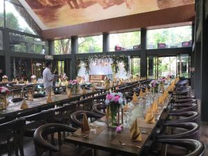 a row of tables in a restaurant with a man in the background at Aswadduma Hotel in Dambulla
