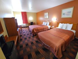 a hotel room with two beds and a television at Days Inn by Wyndham Lumberton in Lumberton