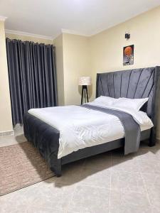 a bedroom with a large bed with a gray headboard at Luxurious 2 bedroom penthouse-Fully Furnished in Kitale