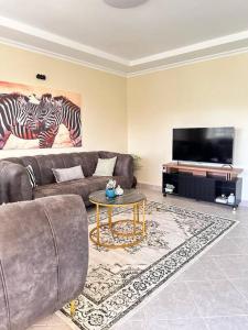 a living room with a couch and a flat screen tv at Luxurious 2 bedroom penthouse-Fully Furnished in Kitale