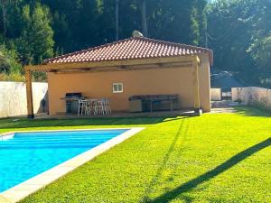 una pequeña casa con piscina en un patio en Casa do Bosque, en Vila Nova de Cerveira