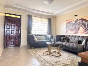 a living room with a couch and a table at Luxurious 2 bedroom penthouse-Fully Furnished in Kitale