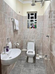 La salle de bains est pourvue de toilettes blanches et d'un lavabo. dans l'établissement Luxurious 2 bedroom penthouse-Fully Furnished, à Kitale