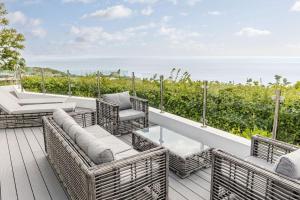 a balcony with wicker furniture and a view of the ocean at Cove Lodge in Portland