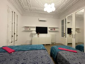 1 dormitorio con 2 camas y TV en el techo en Bcn Centric Rooms, en Barcelona
