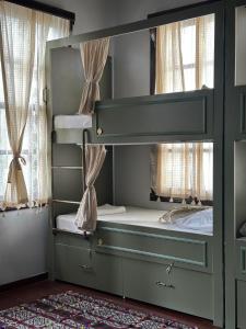 a bedroom with a bunk bed with two windows at LORDS HOSTEL & PUB in Antalya