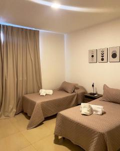 ein Hotelzimmer mit 2 Betten und einem Fenster in der Unterkunft Dptos Corrientes con cochera in Corrientes