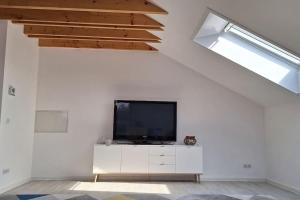 uma sala de estar com televisão numa parede branca em Gemütliche Wohnung in Bissingen em Bietigheim-Bissingen