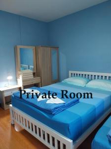 ein blaues Schlafzimmer mit einem großen Bett und einem blauen Zimmer in der Unterkunft Home of River Kwai in Kanchanaburi