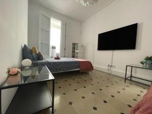 1 dormitorio con 1 cama y TV de pantalla plana en Bcn Centric Rooms en Barcelona