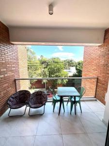 a patio with a table and chairs on a balcony at Hermoso apartamento en Asuncion in Asuncion