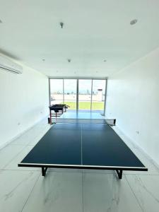 a ping pong table in a room with a large window at Hermoso apartamento en Asuncion in Asunción
