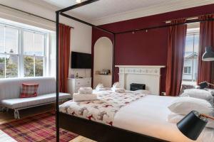 - une chambre avec un grand lit et une cheminée dans l'établissement Cawdor House B&B, à Nairn