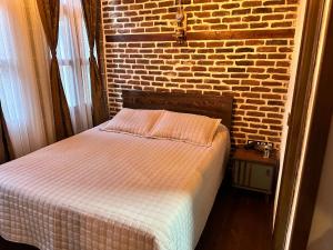 1 cama en un dormitorio con pared de ladrillo en Karga Butik Otel en Diyarbakır