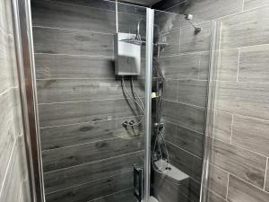 a bathroom with a shower with a wooden wall at Karga Butik Otel in Diyarbakır