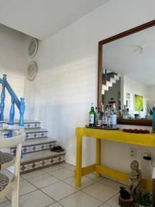 a room with a mirror and a table and stairs at Casa Amarela, para veraneio em Areia Dourada in Cabedelo