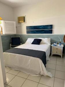 a bedroom with a large bed with a blue headboard at Casa Amarela, para veraneio em Areia Dourada in Cabedelo