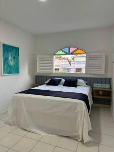 a bedroom with a large bed with a window at Casa Amarela, para veraneio em Areia Dourada in Cabedelo