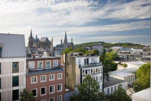 a view of a city with buildings and churches at POHA House Theaterplatz in Aachen