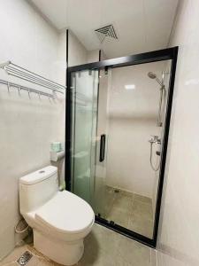 a bathroom with a toilet and a glass shower at House of Great White Apartment in Shenzhen