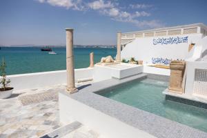 een zwembad met de oceaan op de achtergrond bij Dar Jamila La Dolce Vita au coeur de la Medina in Hammamet