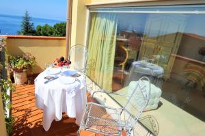 a table and chairs on a balcony with a view of the ocean at Hotel Scilla in Scilla