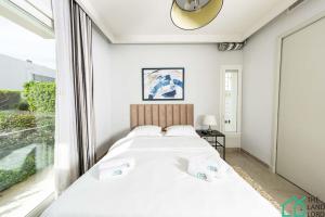 1 Schlafzimmer mit 2 Betten und einem großen Fenster in der Unterkunft Villa Cassel: Villa avec piscine et vue sur le lac in Tunis