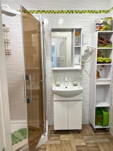 a bathroom with a white sink and a shower at Flower Breeze in Chebanka
