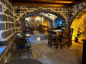 a restaurant with tables and chairs in a stone wall at Karga Butik Otel in Diyarbakır