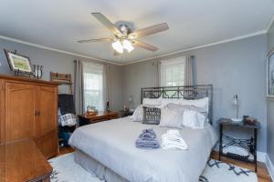 een slaapkamer met een wit bed en een plafondventilator bij House Near Bju, Furman, & Town in Greenville