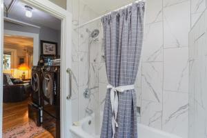 a bathroom with a shower with a shower curtain at House Near Bju, Furman, & Town in Greenville +50 photos
