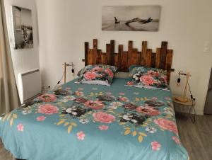 uma cama com um edredão azul com flores em Launay em Chènehutte-les-Tuffeaux