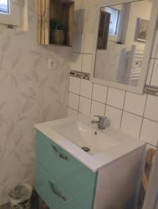 uma casa de banho com um lavatório e um espelho em Launay em Chènehutte-les-Tuffeaux