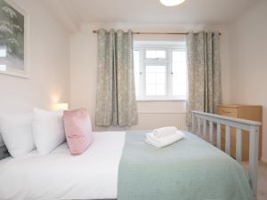 a bedroom with a bed and a window at Cosy 2 Bedroom Flat with Parking and 20mins Train to London in Maidenhead