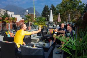 Eine Gruppe von Männern, die an einem Tisch sitzen. in der Unterkunft Colorado Hotel in Lugano