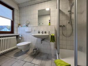 ein Badezimmer mit Waschbecken, Dusche und Toilette in der Unterkunft Am Obersee Hotel in Simmerath