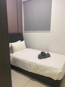 een bed met een hoed erop bij Greenfield Residence Comfort Stay Near sunway pyramid, sunway college, one academy, taylors uni in Petaling Jaya