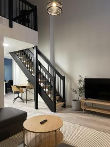 a living room with a staircase and a table at Spacious loft apartment with Lake Näsijärvi views in Tampere