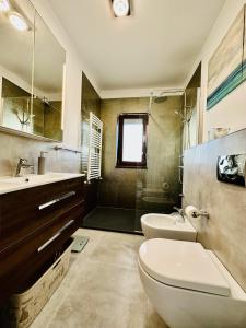 een badkamer met een toilet, een wastafel en een spiegel bij Adria Apartment in Râmnicu Vâlcea