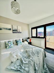 een slaapkamer met een groot bed en 2 handdoeken bij Adria Apartment in Râmnicu Vâlcea