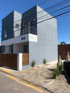 un edificio blanco y negro en una calle en Casa com Piscina em Xangri-Lá RS en Xangri-lá