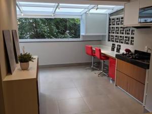 a kitchen with red stools and a large window at VN Turiassu in Sao Paulo