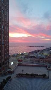een uitzicht op de oceaan vanuit een gebouw bij zonsondergang bij شقه للايجار عالبحر مباشره in Alexandrië