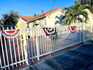 a white picket fence with american flags on it at Lovely 1-Bedroom Apartment in Miami