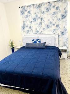 a bedroom with a blue bed with a blue and white pillow at Lovely 1-Bedroom Apartment in Miami