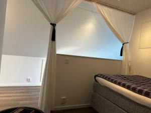 1 dormitorio con ventana y 1 cama con cortinas en Yngsjövång en Yngsjö