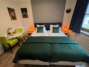 een slaapkamer met een groot bed en een tafel en stoelen bij Am Obersee Hotel in Simmerath